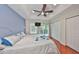 A primary bedroom featuring a ceiling fan, sliding glass doors, a closet and wood floors at 618 Wheaton Trent Pl, Tampa, FL 33619