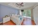 A cozy primary bedroom featuring a ceiling fan, sliding glass doors and wood floors at 618 Wheaton Trent Pl, Tampa, FL 33619