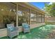 Relaxing back patio boasts comfortable seating, a lush green lawn, and large windows offering beautiful views at 6213 S Queensway Dr, Temple Terrace, FL 33617
