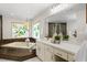 Bathroom showcasing a garden tub, vanity, and a stained glass window at 6213 S Queensway Dr, Temple Terrace, FL 33617