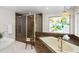 Bathroom features a glass-enclosed shower, soaking tub, and decorative stained glass window at 6213 S Queensway Dr, Temple Terrace, FL 33617