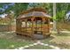 Wooden gazebo with built-in benches and intricate details, perfect for enjoying the outdoors at 6213 S Queensway Dr, Temple Terrace, FL 33617