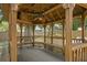 Charming gazebo interior with wooden benches and a ceiling fan, creating a cozy outdoor retreat at 6213 S Queensway Dr, Temple Terrace, FL 33617