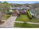 Aerial view of a charming single-story brick home with a lush green lawn and well-maintained landscaping at 6352 Huntington Dr, Zephyrhills, FL 33542