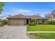 Charming single-story brick home featuring a two-car garage, manicured lawn, and beautiful paver driveway at 6352 Huntington Dr, Zephyrhills, FL 33542