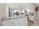 Bright kitchen with white cabinetry, stainless steel appliances, and a peninsula island with bar stool seating at 6352 Huntington Dr, Zephyrhills, FL 33542