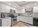 Well-lit kitchen featuring white cabinets, stainless steel appliances, and modern fixtures for culinary enthusiasts at 6352 Huntington Dr, Zephyrhills, FL 33542