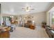 Bright living room with plush carpeting, ceiling fan, and multiple seating options, creating a welcoming space at 6352 Huntington Dr, Zephyrhills, FL 33542