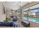 Relaxing sunroom featuring comfortable seating, ceiling fan, and a picturesque view of the sparkling pool at 6352 Huntington Dr, Zephyrhills, FL 33542