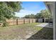 Spacious backyard featuring a wood fence, lush trees, storage shed, and a small concrete patio at 6481 64Th N Ave, Pinellas Park, FL 33781