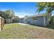 Backyard view showcasing a blue house, storage shed, wooden fence, and a small patio area at 6481 64Th N Ave, Pinellas Park, FL 33781