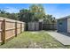 Wide fenced backyard with green space, storage shed, concrete patio, and palm tree views at 6481 64Th N Ave, Pinellas Park, FL 33781