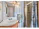 Bathroom featuring a sink with vanity, a mirror, striped wallpaper and a shower behind a glass door at 7045 El Dewitt St, Zephyrhills, FL 33541