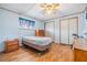 Bedroom with wood-look floors, a dresser, a bed frame on wheels and window with a blue curtain at 7045 El Dewitt St, Zephyrhills, FL 33541