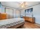 Bedroom with wood-look floors, two closets, a dresser and window with a blue curtain at 7045 El Dewitt St, Zephyrhills, FL 33541