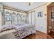 Cozy bedroom featuring a full bed, wood floors, a ceiling fan and window overlooking the community at 7045 El Dewitt St, Zephyrhills, FL 33541