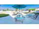 Community pool featuring a poolside lounge area with tables, umbrellas, and chairs at 7045 El Dewitt St, Zephyrhills, FL 33541