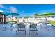 Poolside lounge area with tables and umbrellas at Spanish Trails Senior Village at 7045 El Dewitt St, Zephyrhills, FL 33541