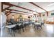 Spacious community room with tables, chairs, wood beam construction, and stone fireplace at 7045 El Dewitt St, Zephyrhills, FL 33541