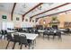 Large community room with tables, chairs, a piano, and a stone fireplace at 7045 El Dewitt St, Zephyrhills, FL 33541