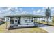 Inviting single-story home featuring a shaded carport and well-kept front yard at 7045 El Dewitt St, Zephyrhills, FL 33541