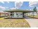 Charming single-story home with an awning, well-maintained lawn, and spacious driveway at 7045 El Dewitt St, Zephyrhills, FL 33541