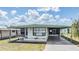 Charming single-story home featuring a shaded carport and well-kept front yard at 7045 El Dewitt St, Zephyrhills, FL 33541