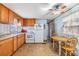 Functional kitchen with wooden cabinets, essential appliances, and a compact dining area at 7045 El Dewitt St, Zephyrhills, FL 33541