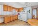 Cozy kitchen with wooden cabinets, white appliances, and ample counter space at 7045 El Dewitt St, Zephyrhills, FL 33541