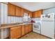 A practical kitchen featuring wood cabinets and white appliances at 7045 El Dewitt St, Zephyrhills, FL 33541