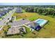 Community aerial view showcasing a playground, pool, clubhouse, parking lot, and green spaces at 7164 Twisting Pines Loop, Zephyrhills, FL 33541