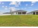 Back of house view showing screened in porch, windows, and well-maintained lawn at 7164 Twisting Pines Loop, Zephyrhills, FL 33541