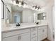 Modern bathroom showcasing a double sink vanity with white cabinets and stylish lighting fixtures at 7164 Twisting Pines Loop, Zephyrhills, FL 33541