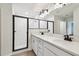 Well-lit bathroom featuring a double sink vanity, and a glass-enclosed shower at 7164 Twisting Pines Loop, Zephyrhills, FL 33541