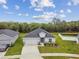 New single-story home features an attached two-car garage, verdant lawn, and white fencing at 7164 Twisting Pines Loop, Zephyrhills, FL 33541