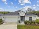 Single-story home boasts a two-car garage, appealing stone accents, and a well-kept front yard at 7164 Twisting Pines Loop, Zephyrhills, FL 33541