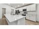 Bright kitchen featuring white cabinets, stainless steel appliances, and a large center island at 7164 Twisting Pines Loop, Zephyrhills, FL 33541