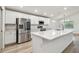 Bright kitchen featuring white cabinets, stainless steel appliances, and a large center island at 7164 Twisting Pines Loop, Zephyrhills, FL 33541