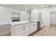 Spacious kitchen with a modern island, stainless steel appliances, and a fireplace on the shiplap wall at 7164 Twisting Pines Loop, Zephyrhills, FL 33541