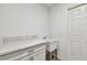 Bright laundry room features a utility sink, countertop, and white cabinets at 7164 Twisting Pines Loop, Zephyrhills, FL 33541