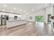 Open-concept living and kitchen area with stainless steel appliances, an island, and sliding doors to outside at 7164 Twisting Pines Loop, Zephyrhills, FL 33541
