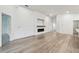 Open living room featuring a modern fireplace, wood mantle, and light wood flooring at 7164 Twisting Pines Loop, Zephyrhills, FL 33541