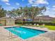 Clean community pool with ladders, a shallow end, pool rules sign and surrounding greenery at 7164 Twisting Pines Loop, Zephyrhills, FL 33541