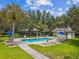 Community pool with ample seating, palm trees, and lush landscaping at 7164 Twisting Pines Loop, Zephyrhills, FL 33541