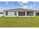 Exterior of back of house with a screened porch and grassy lawn at 7164 Twisting Pines Loop, Zephyrhills, FL 33541