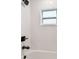 White tiled shower features a window and black hardware adding a modern touch to the space at 7164 Twisting Pines Loop, Zephyrhills, FL 33541