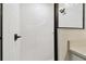 This walk-in shower features white tile and a modern dark shower door and hardware at 7164 Twisting Pines Loop, Zephyrhills, FL 33541