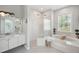 Bright bathroom showcases a soaking tub, walk-in shower, dual shower heads, and a vanity at 806 Linwood Ter, Lutz, FL 33549