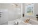 Bright bathroom showcasing a walk-in shower, soaking tub, and a window with natural light at 806 Linwood Ter, Lutz, FL 33549