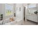 Stylish bathroom with a soaking tub, a window, and a view into an adjoining second bathroom at 806 Linwood Ter, Lutz, FL 33549